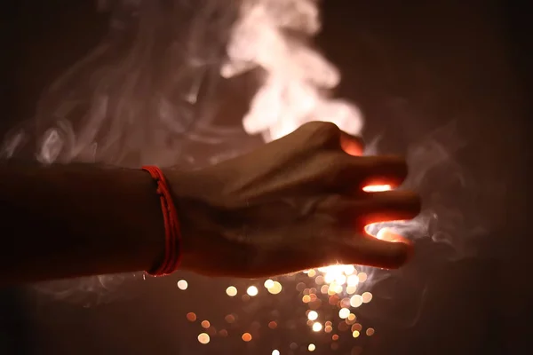 Mano celebración de bengalas sobre fondo negro — Foto de Stock