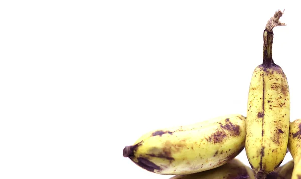 Rijp gele bananen fruit, bos rijpe bananen met donkere vlekken op een witte achtergrond. — Stockfoto