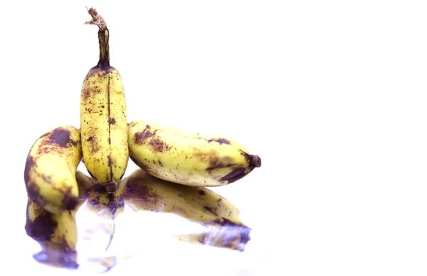 Rijp gele bananen fruit, bos rijpe bananen met donkere vlekken op een witte achtergrond. — Stockfoto