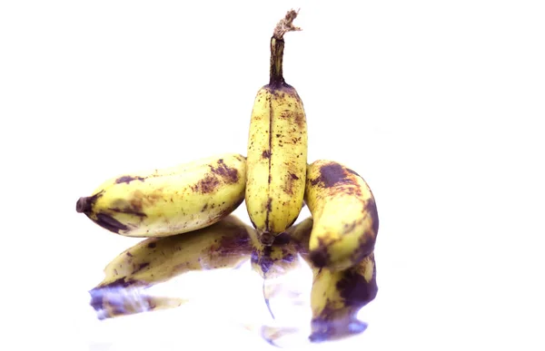 Rijp gele bananen fruit, bos rijpe bananen met donkere vlekken op een witte achtergrond. — Stockfoto