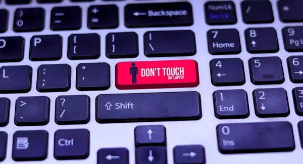 Red key alert message with Don't touch My Laptop icon on laptop keyboard.
