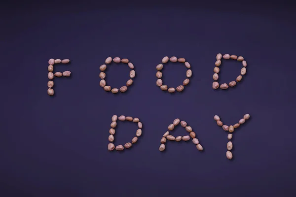 Concepto del Día Mundial de la Alimentación: palabras de los cacahuetes sobre el fondo negro . — Foto de Stock
