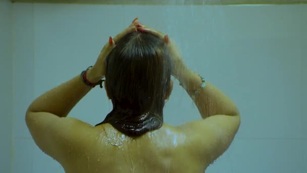 Brunette Indian woman washing hair in the shower. Closeup. View from back. Back view of hot woman posing on camera in bathroom. — Stock Video