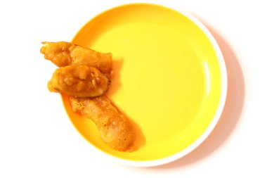 Vazhakkai Bajji (Çiğ muz Bajji) beyaz arka planda sarı bir tabakta hizmet verdi