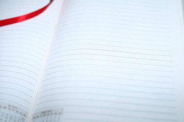 Beyaz arkaplanda satırları olan boş sayfalarla açılan günlük, seçici odaklı yakın çekim.