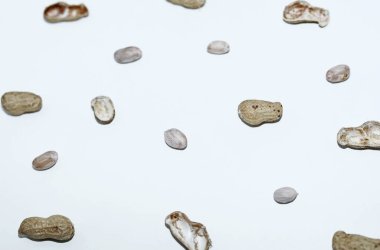 Fıstık kabuklarının ve soyulmuş fıstıkların beyaz arka planda üst görüntüsü