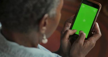 Afrikalı-Amerikalı kadın kıdemli manifatura onun başparmak yeşil ekran telefon ile