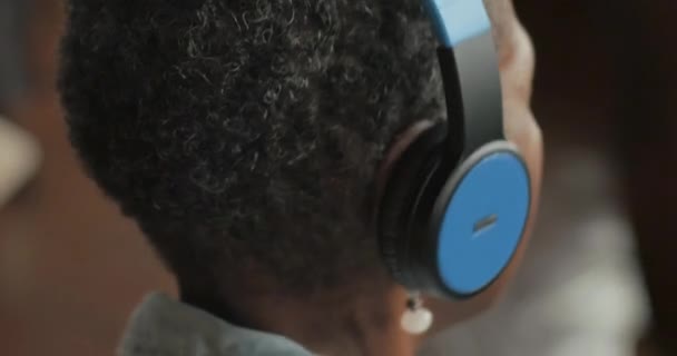 Mulher idosa negra usando fones de ouvido sem fio ouvindo música — Vídeo de Stock