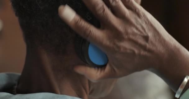Mujer afroamericana mayor que se pone auriculares inalámbricos — Vídeos de Stock
