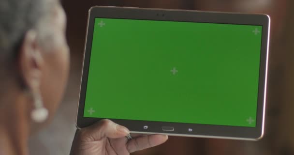 Senior svart kvinna att svepa och trycka på en grön skärm digital tablett - Ots — Stockvideo