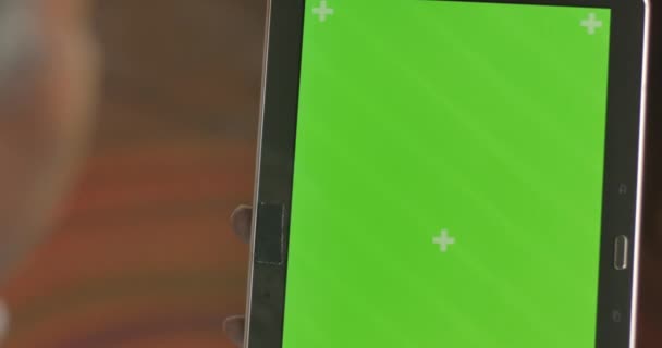 Černá ruka výčepní a posouvání na zelené obrazovce displej digitální tabletu