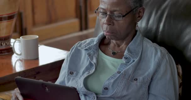 Gezonde zwarte baby boomer senior vrouw met behulp van een digitaal tablet — Stockvideo