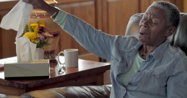 Больной пожилой черной женщиной с простудой, сморкающейся в нос салфеткой — стоковое видео
