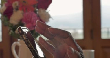 Siyah bir kadının aşağı eğim pinching ve bir akıllı telefon kullanarak eller