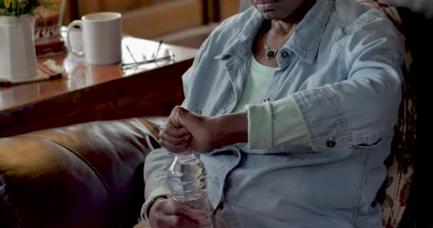 Oudere senior vrouw drinkwater uit een plastic fles — Stockvideo