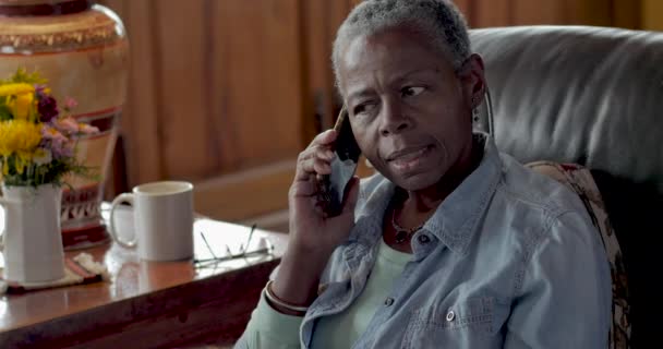Irriterad senior svart kvinna besvara hennes mobiltelefon — Stockvideo