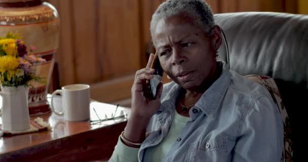 Ongelukkig oudere zwarte vrouw praten over haar mobiele telefoon schudt haar hoofd niet — Stockvideo