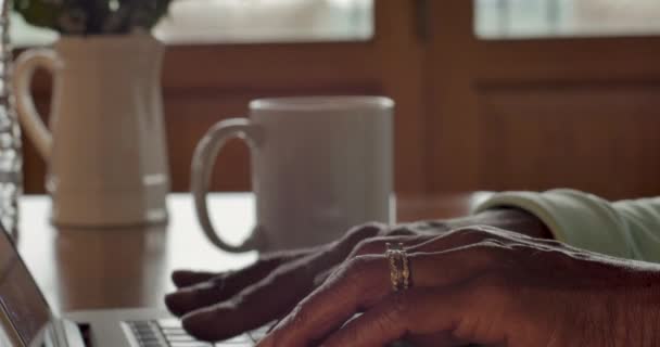 Närbild av en svart kvinnas händer att skriva på en laptop tangentbord — Stockvideo