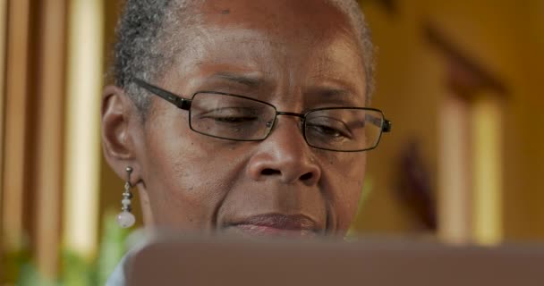 Attractive elderly black woman looking at her laptop computer screen — Stock Video