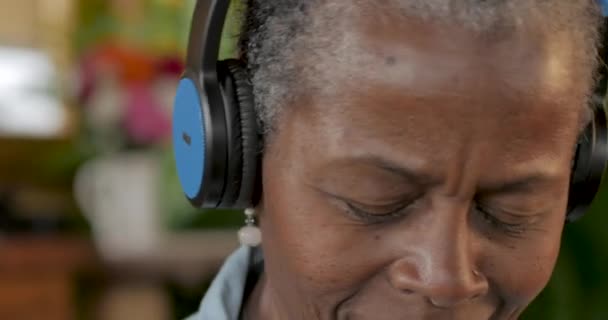 魅力的なアフリカ系アメリカ人の年配の女性の彼女の目を閉じて音楽を聴く — ストック動画