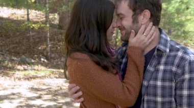 Genç çekici çift öpüşme, sarılma ve ormanda sevgi gösteren