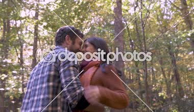 Çekici kadın sonbahar sırasında yakışıklı bir adamın kafasına yaprakları atma