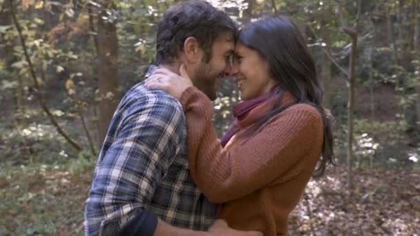 Couple ludique jetant des feuilles l'un sur l'autre dans un parc ou un sentier de randonnée — Video