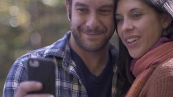 Beautiful young man and woman taking a selfie while outside in the woods — Stock Video