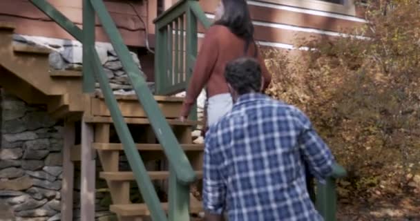 Paar geht Außentreppe hinauf, um ihre haustierfreundliche Ferienwohnung zu betreten — Stockvideo