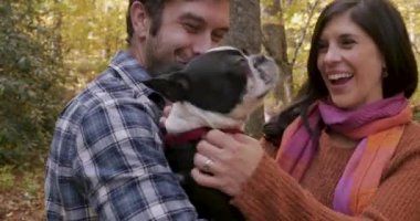 Mutlu genç heyecanlı çift tutarak ve bir Boston terrier küçük köpek Evcil hayvan çiftliği