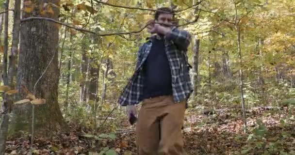 Чоловік, що йде один в лісі, підкреслив, намагаючись використовувати свій мобільний телефон — стокове відео
