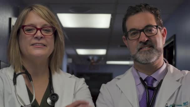 İki emin doktorlar kollarını geçerek ve kamera bakıyor — Stok video