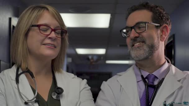 Άνδρες και γυναίκες γιατροί στραφούν, χαμογελούν και να κοιτάξουμε ο ένας τον άλλο σε αργή κίνηση — Αρχείο Βίντεο