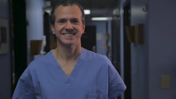 Portrait of a man in blue scrubs turning to the side and crossing his arms — Stock Video