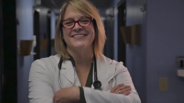 Porträt einer Ärztin, die zwinkernd die Arme verschränkt und in die Kamera blickt — Stockvideo