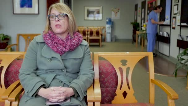 Pasien perempuan duduk di rumah sakit atau ruang tunggu kantor medis — Stok Video