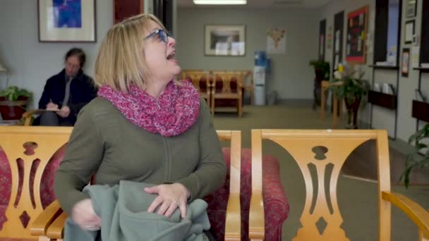 Mujer en una sala de espera del hospital recibiendo buenas noticias de su médico — Vídeos de Stock