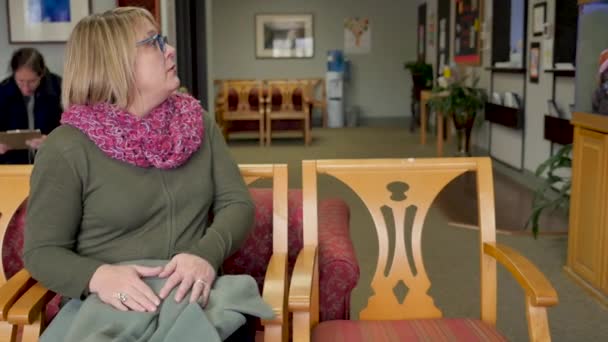 Gütiger, mitfühlender Arzt, der neben einer Frau im Wartezimmer sitzt — Stockvideo