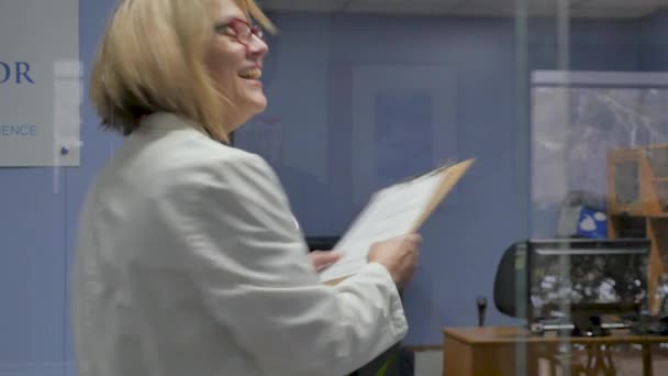 Portret pięknej kobiecej lekarz toczenia, uśmiechnięty, i patrząc na kamerę — Wideo stockowe