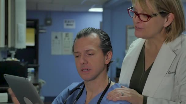 タブレットを見て幸せな男性と女性の医師は、ケースのコンサルティング — ストック動画
