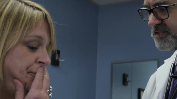 Médico do sexo masculino dando uma paciente do sexo feminino notícias ruins ou graves em uma sala de exame — Vídeo de Stock