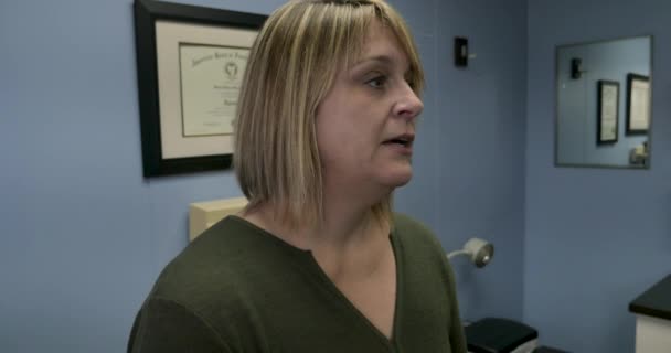 Pasien perempuan membosankan mendesah dan menunggu untuk dilihat oleh dokter di ruang ujian — Stok Video