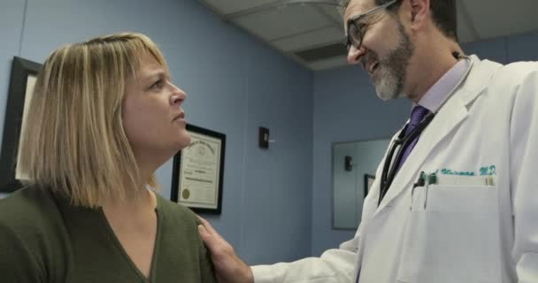Медичний лікар надає поганий діагноз пацієнтці-жінці турботливим чином — стокове відео