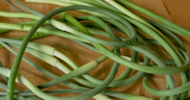 Overhead shot of a bunch of organic, fresh, seasonal, spring, garlic scapes — Stock Video