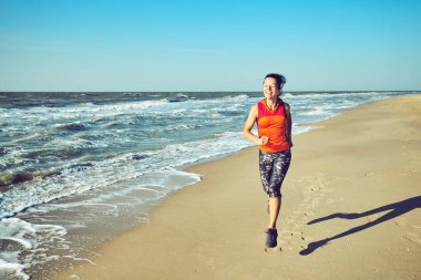 Çalışan kadın. Kadın atlet açık egzersiz sırasında beach dinleme koşu