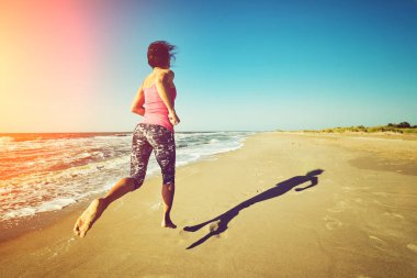 Çalışan kadın. Kadın atlet açık egzersiz sırasında beach dinleme koşu