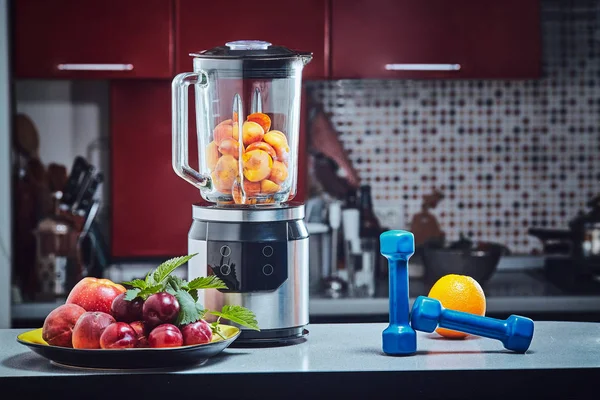 The electric blender for make fruit juice or smoothie on wooden kitchen table.