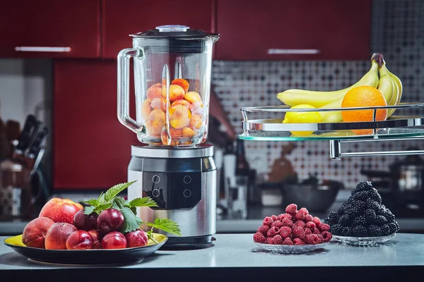 The electric blender for make fruit juice or smoothie on wooden kitchen table.
