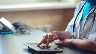 Hastanede tablet bilgisayar kullanan kadın doktor.