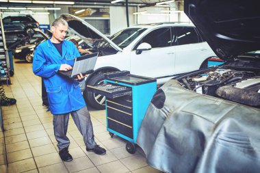 Tamirci adam otomotiv tanı tarayıcı ve araç sistemi atölye kontrol panosu